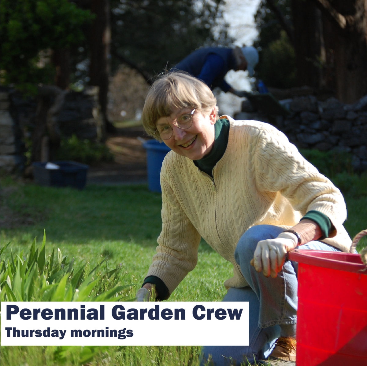 Female volunteer kneeling in a garden with a bucket